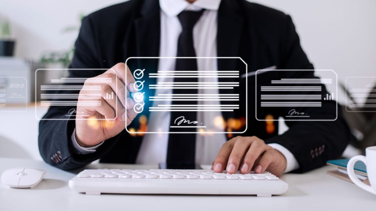 image | Digilite | Web Design Company in Glendale CA Business professional in a suit planning and reviewing strategy documents on an interactive digital interface.